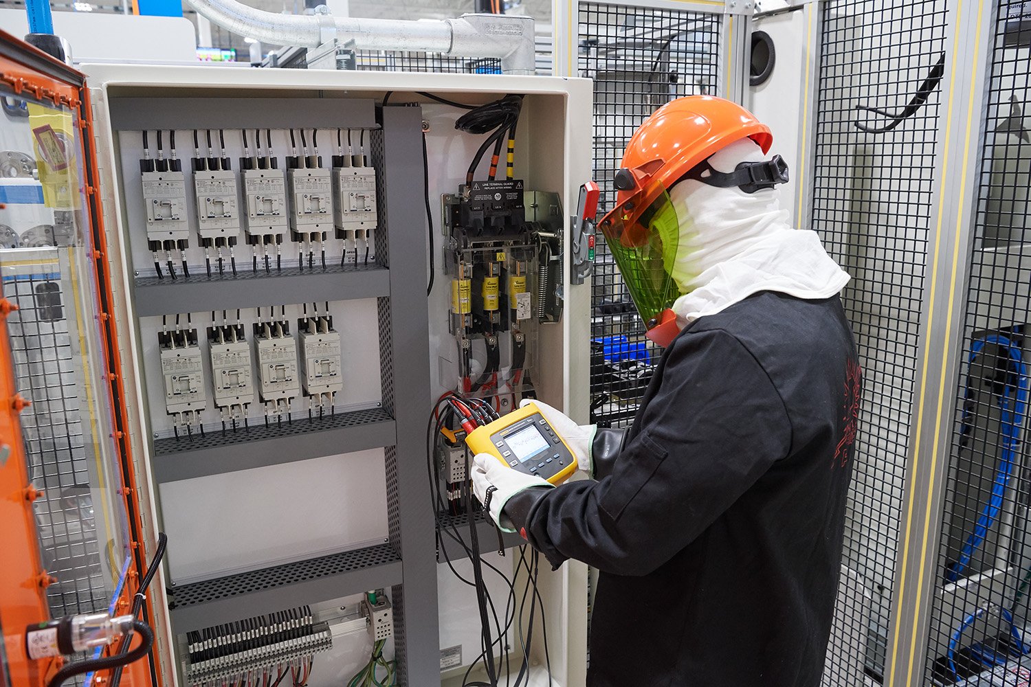 Dana technician sets up a power monitor within an electrical panel.