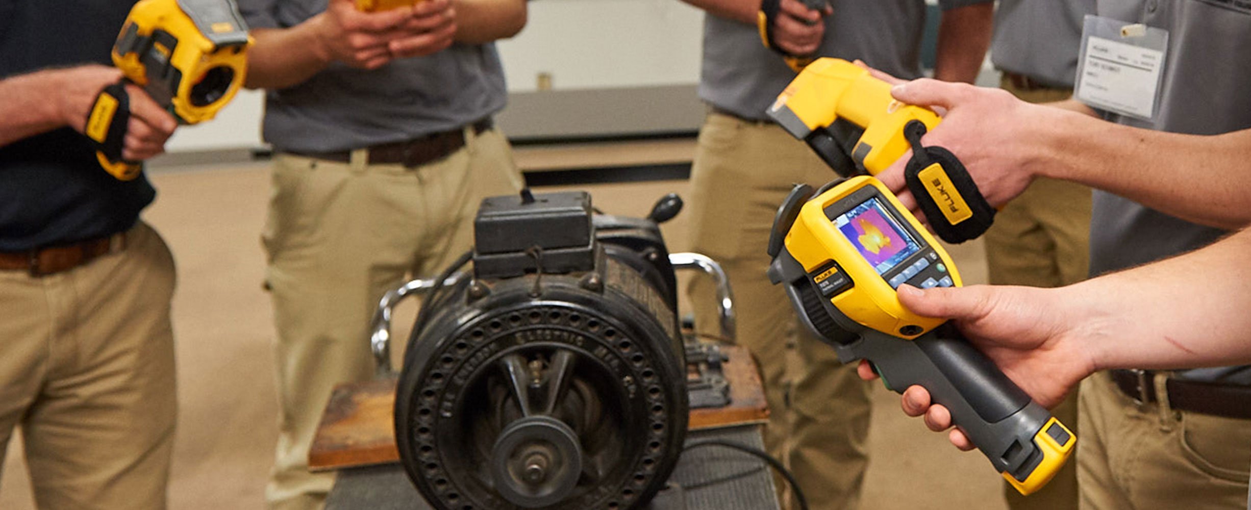 Studenten inspecteren een motor met Fluke-infraroodcamera's tijdens een opleiding