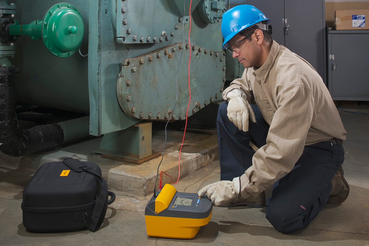 An electrician uses a Fluke 1550 Series insulation resistance testing meter to make measurements on a motor
