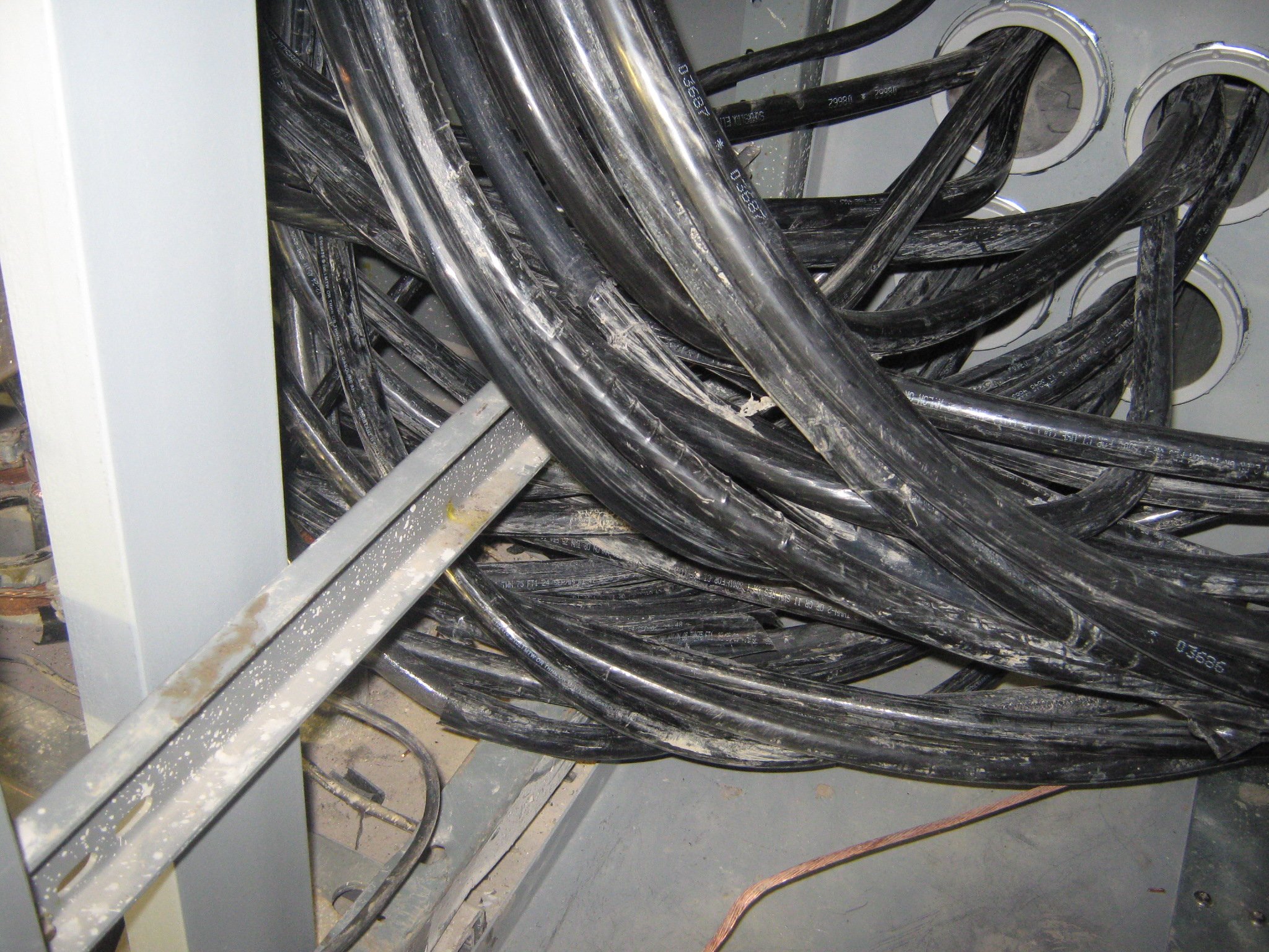 Câbles reposant sur un canal de support métallique, créant un risque de chauffage par induction.