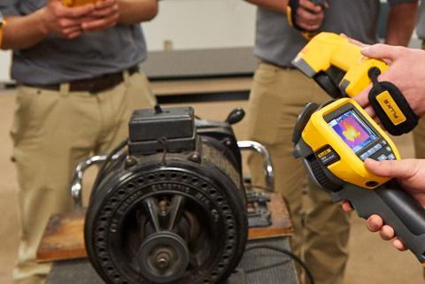 Studenten inspecteren een motor met Fluke-infraroodcamera's tijdens een opleiding